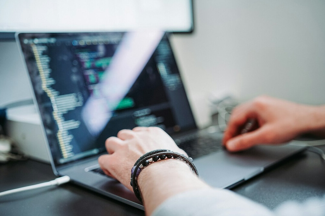 programmer typing code on laptop