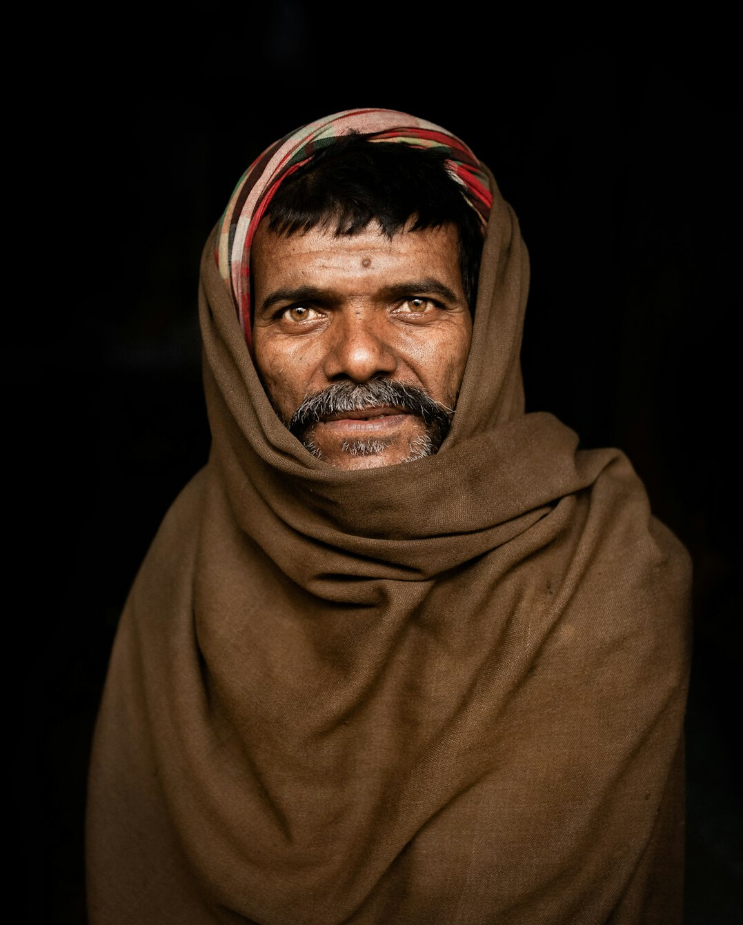 Studio portrait of a young Malaysian Indian man smiling
