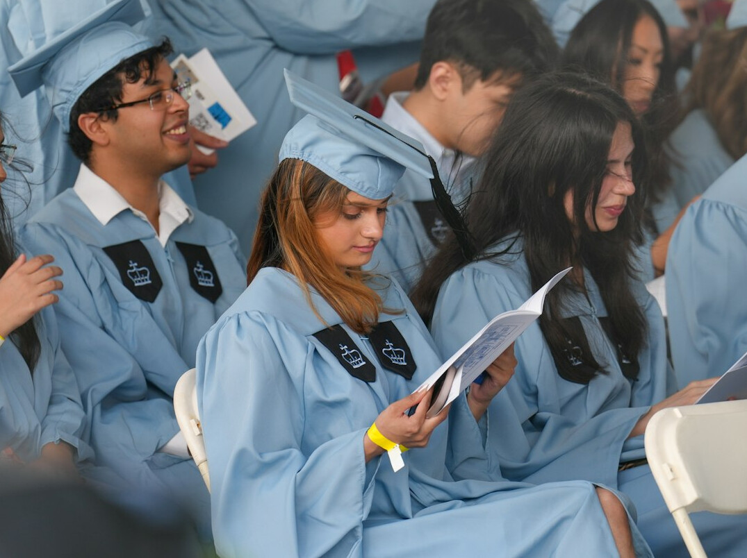 Small group of students studying together around a laptop with notes