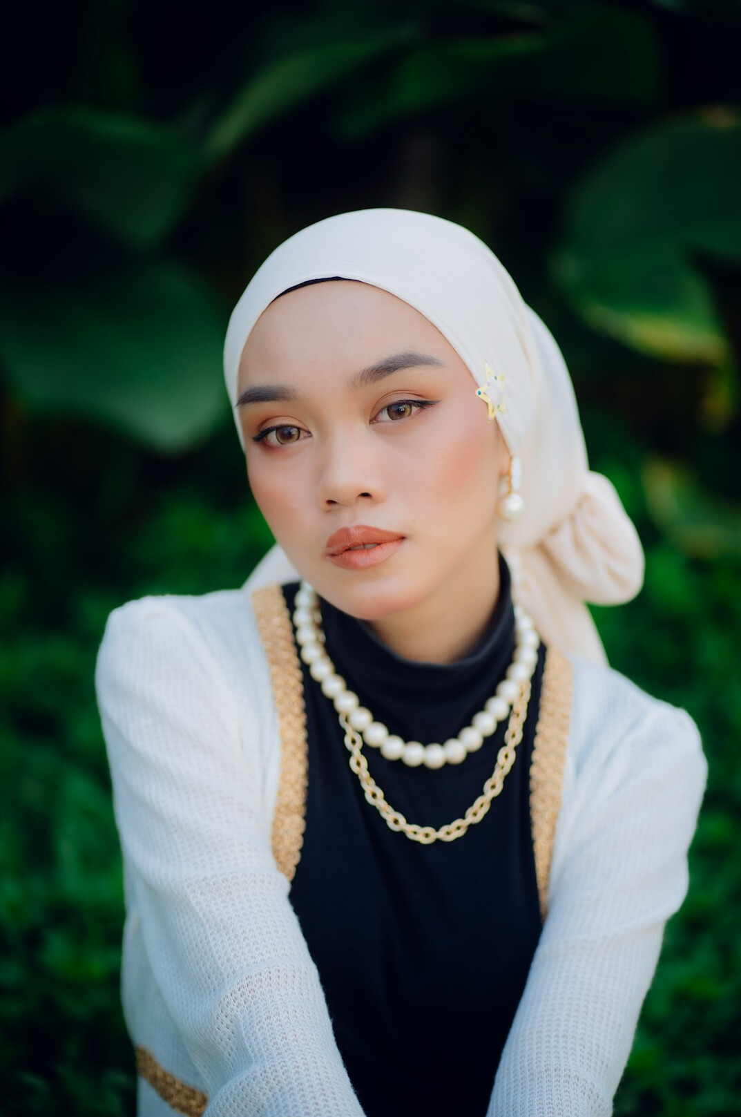 Studio portrait of a young Malay woman wearing a hijab smiling